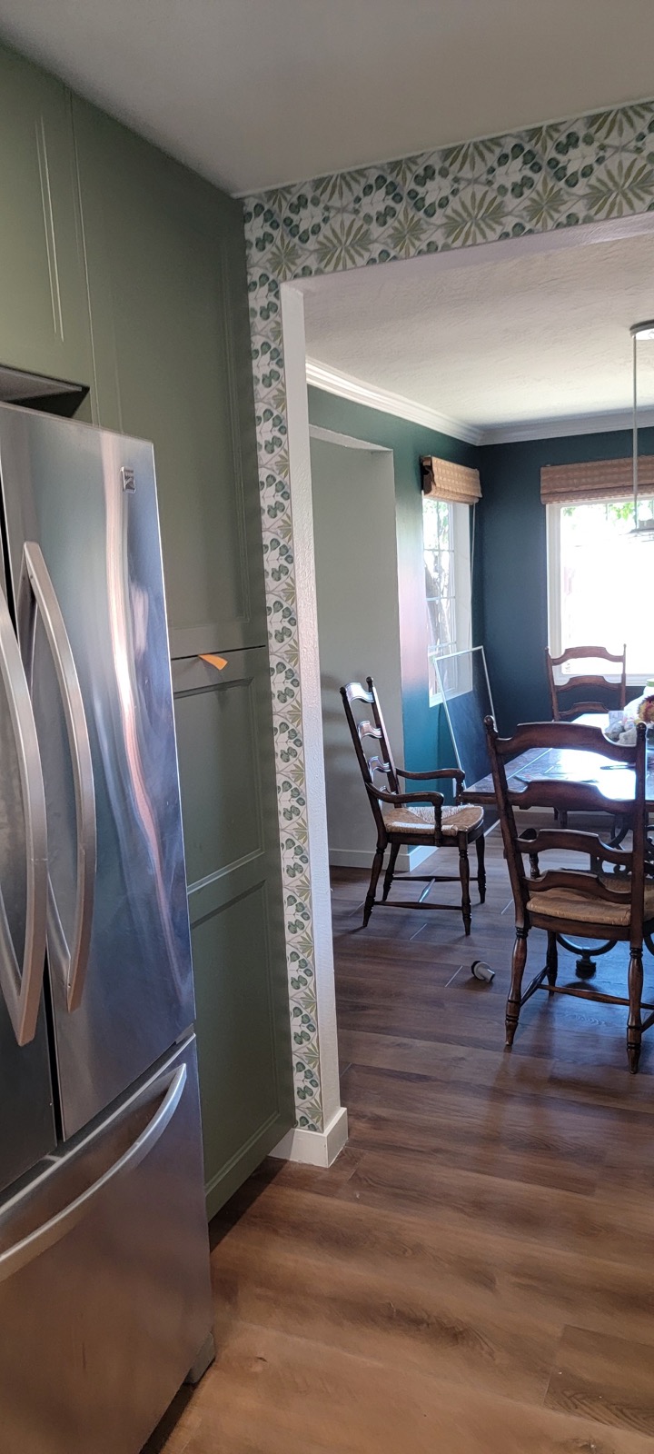 Kitchen detail with green cabinetry and view into dining space.